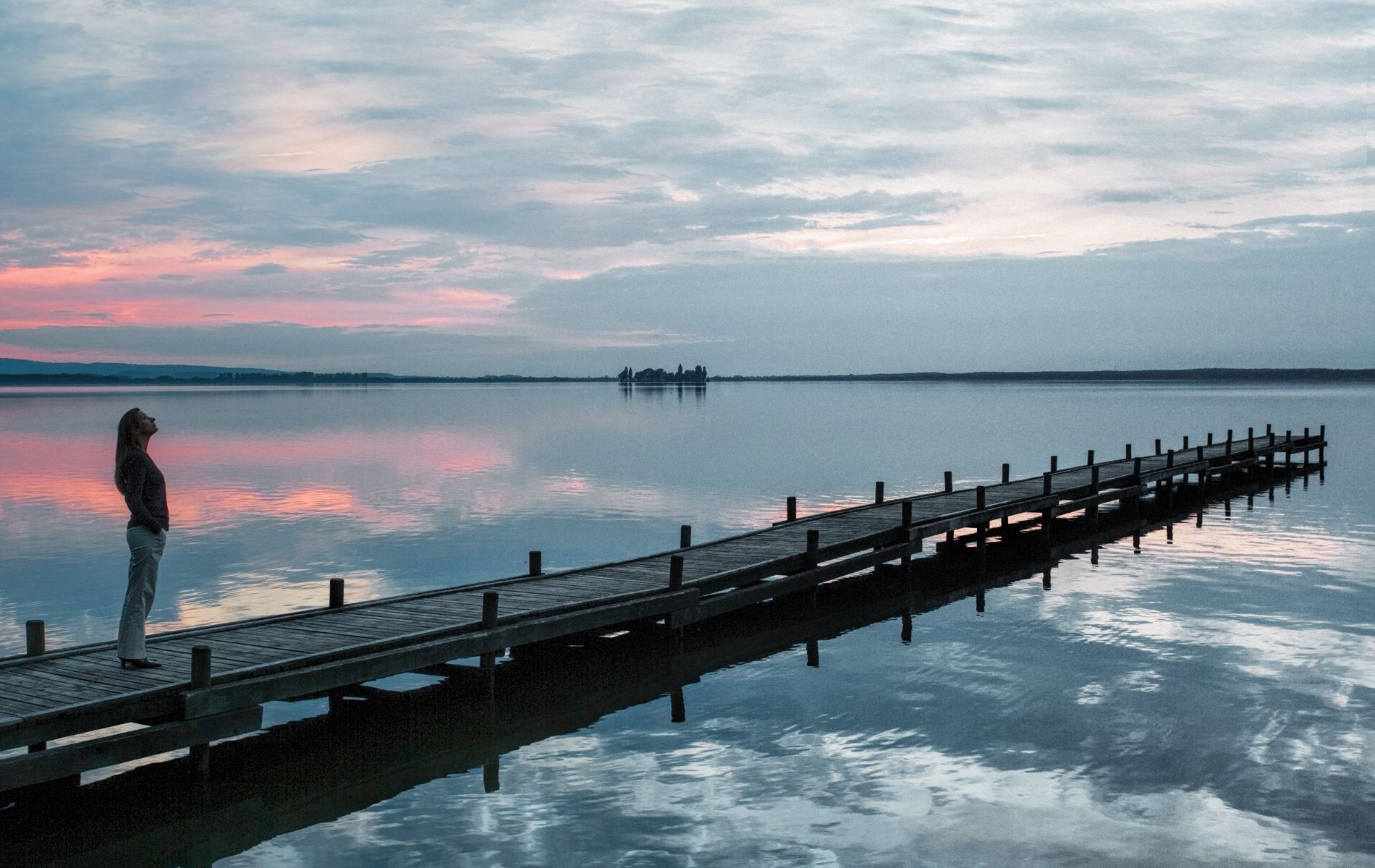 Femme sur un ponton entrain de regarder le ciel